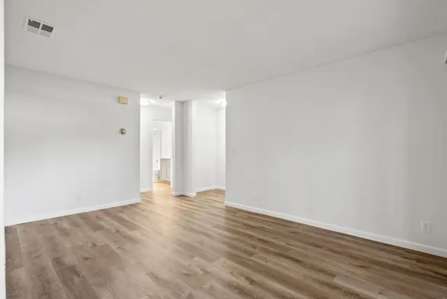 a view of an empty room with wooden floor