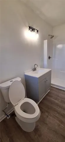 a bathroom with a toilet a sink and mirror