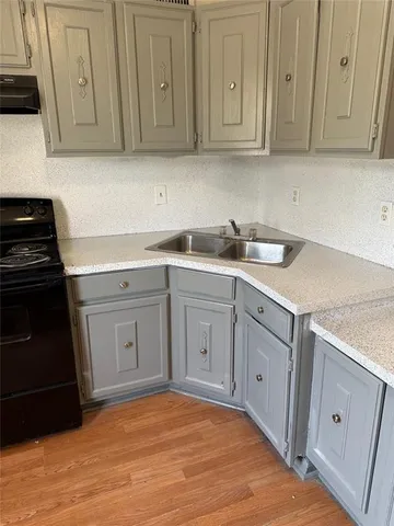 a view of an empty room with wooden floor and closet
