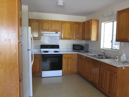 8562 Kekaha Road Kekaha, HI 96752 - Photo 4 of 12 a kitchen with granite countertop a stove sink and cabinets