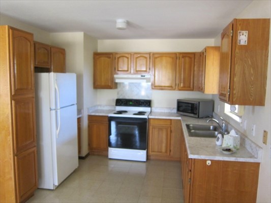 8562 Kekaha Road Kekaha, HI 96752 - Photo 6 of 12 a kitchen with granite countertop a refrigerator and a stove