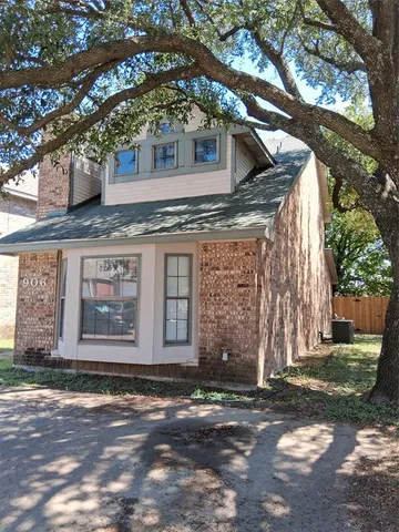 a front view of a house with a tree
