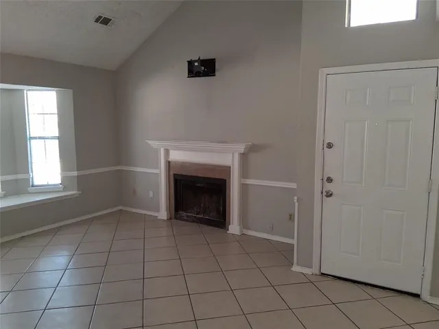 a view of an empty room with window and fire place