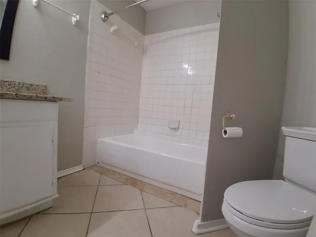 a bathroom with a granite countertop sink a mirror and a bathtub