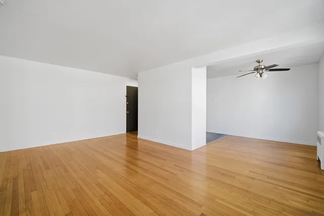 a view of an empty room with wooden floor