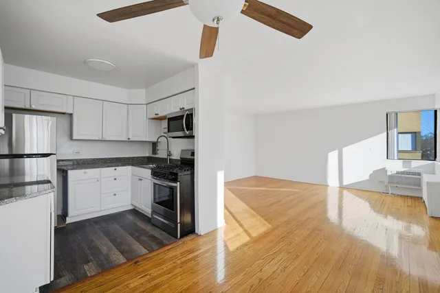 a kitchen with granite countertop a refrigerator and a stove top oven