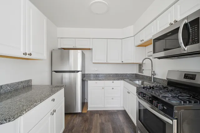 a kitchen with stainless steel appliances granite countertop a stove a refrigerator and a microwave