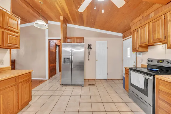 a kitchen with stainless steel appliances granite countertop a refrigerator a stove and a sink with cabinets