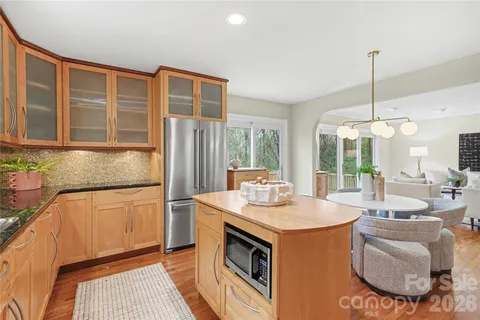 a kitchen with stainless steel appliances granite countertop a stove a sink and a refrigerator with wooden floor