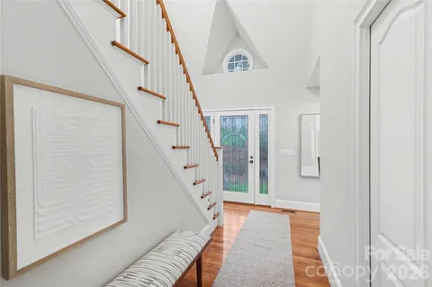 a view of a hallway with wooden floor and staircase