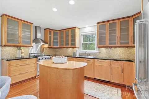 a kitchen with stainless steel appliances granite countertop a sink stove and cabinets