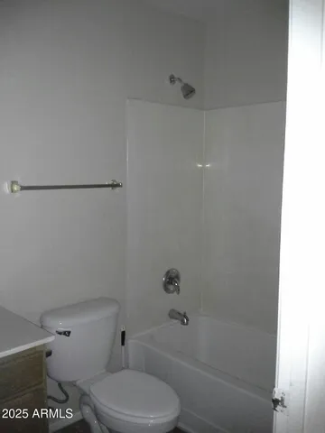 a white toilet sitting next to a bath tub