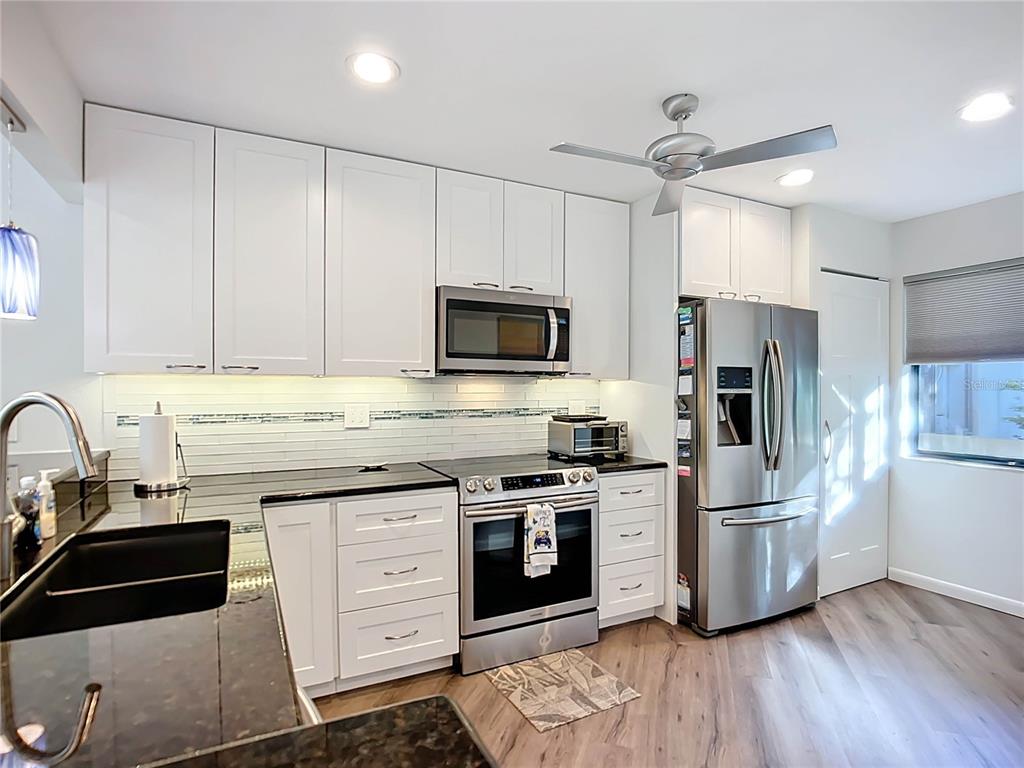 1508 Pelican Cove Road, Unit GR232 Sarasota, FL 34231 - Photo 7 of 54 a kitchen with granite countertop a refrigerator stove and sink