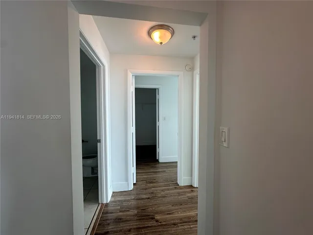 a view of a hallway with wooden floor