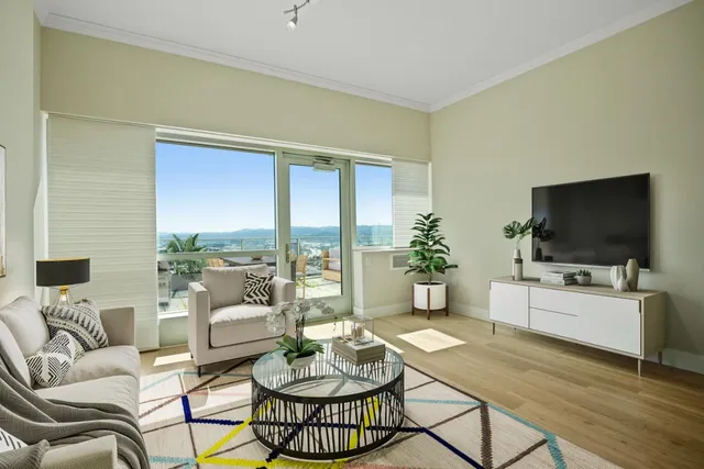 a living room with furniture a flat screen tv and a large window