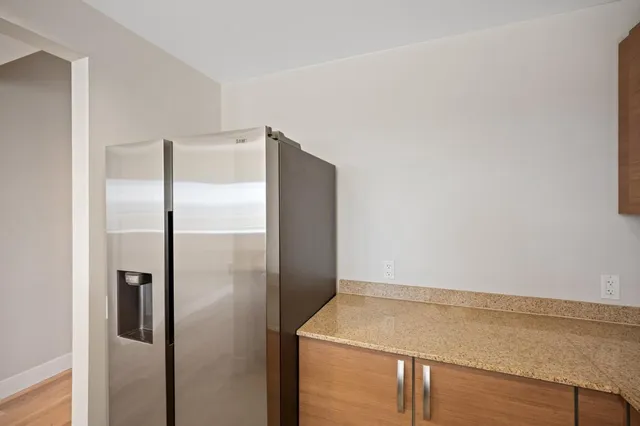 a room with a refrigerator and ceiling fan