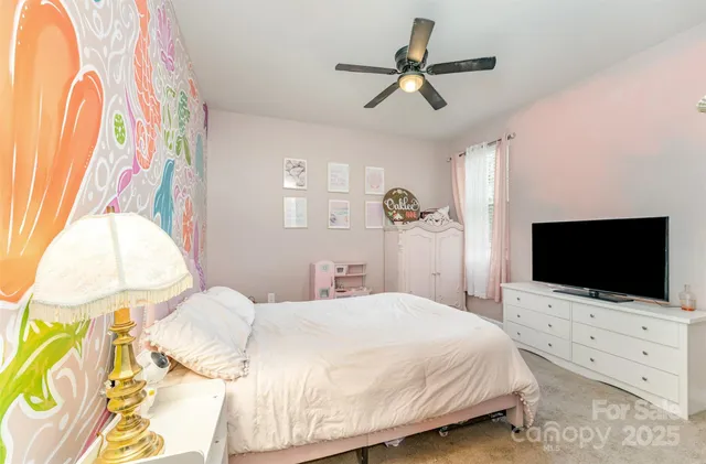a bedroom with a bed window and a flat screen tv