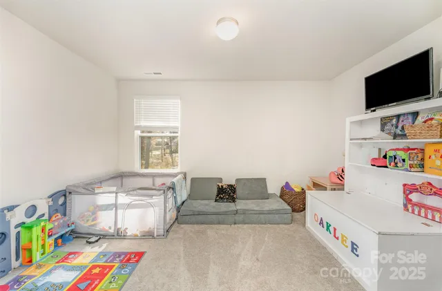 a bedroom with a bed a flat screen tv and a window