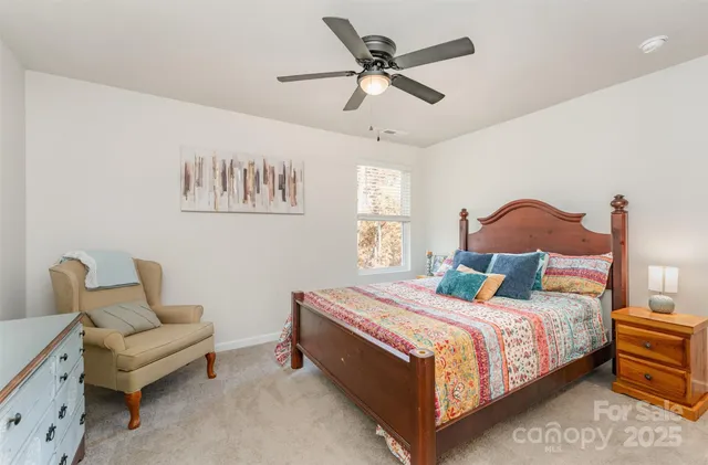 a bedroom with a bed a couch and a chandelier
