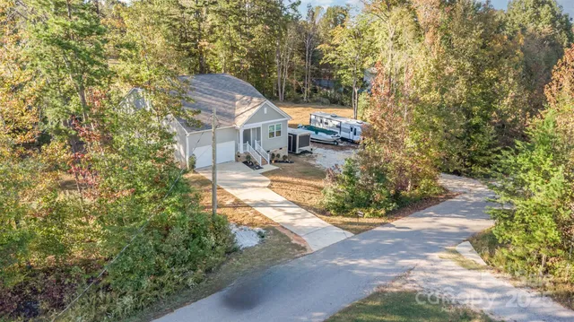 a view of a house with a yard and large trees