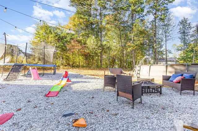 a backyard of a house with barbeque oven table and chairs