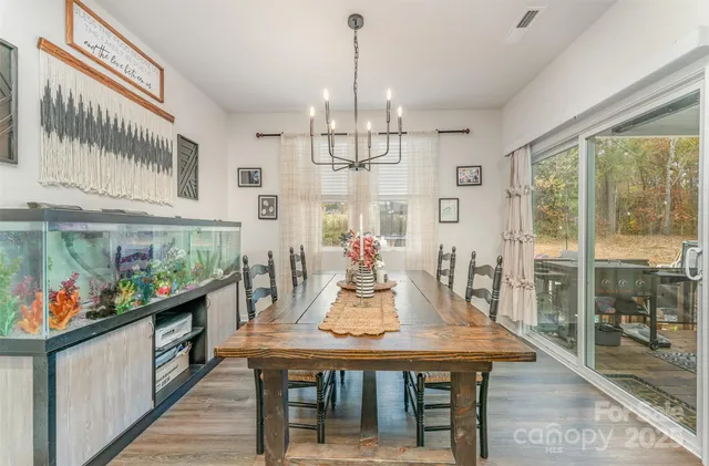 a view of a dining room with furniture a chandelier and wooden floor