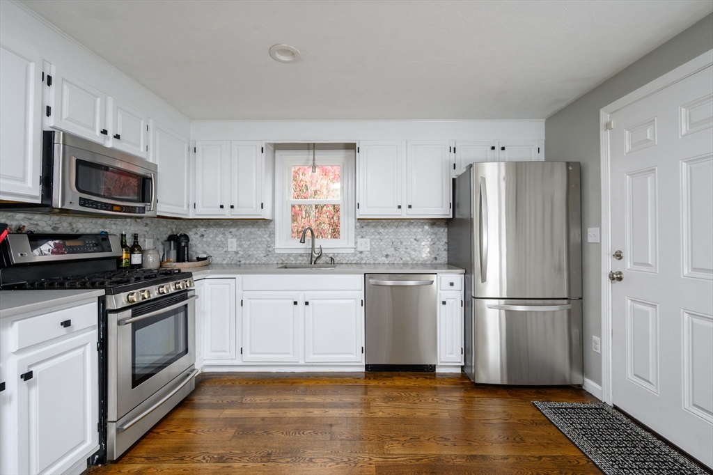 67 School Street Hanover, MA 02339 - Photo 4 of 29 a kitchen with stainless steel appliances granite countertop a refrigerator stove a sink and a microwave