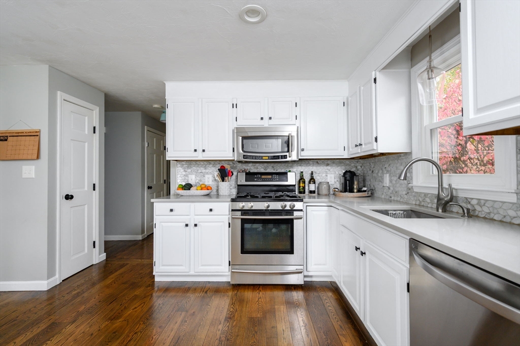 67 School Street Hanover, MA 02339 - Photo 5 of 29 a kitchen with stainless steel appliances granite countertop a stove and white cabinets