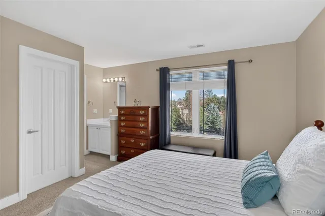 a bedroom with a bed and dresser with mirror