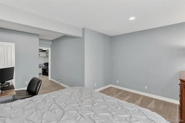 a bedroom with a bed and a computer on the desk