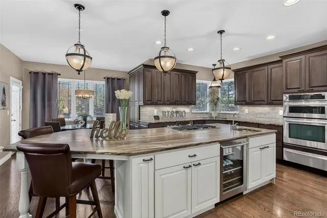 a kitchen with kitchen island granite countertop a sink cabinets and stainless steel appliances