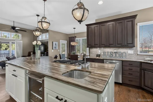 a kitchen with granite countertop a sink a stove and a wooden floors