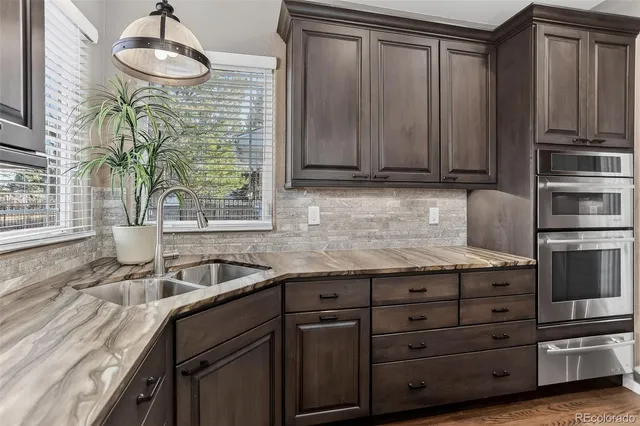 a kitchen with granite countertop a sink stainless steel appliances and cabinets