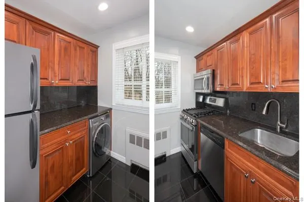 a kitchen with stainless steel appliances granite countertop a stove a sink and a refrigerator with wooden cabinets