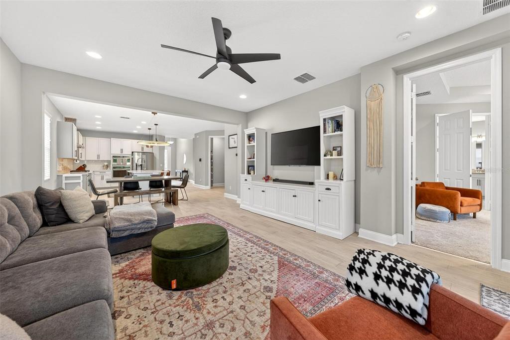 2139 Bay Line Road Oakland, FL 34787 - Photo 14 of 57 a living room with furniture a flat screen tv and kitchen view