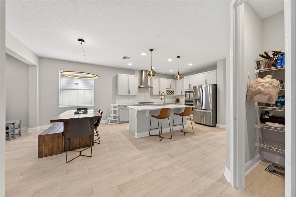 2139 Bay Line Road Oakland, FL 34787 - Photo 20 of 57 a kitchen with stainless steel appliances kitchen island a table and chairs in it