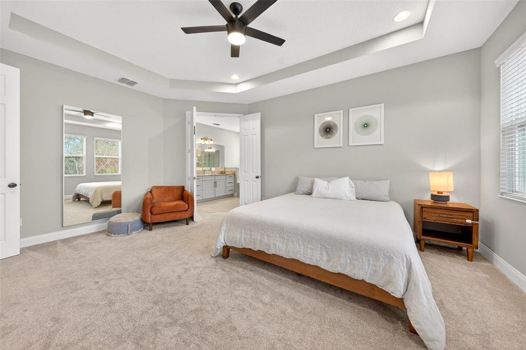 2139 Bay Line Road Oakland, FL 34787 - Photo 23 of 57 a spacious bedroom with two beds and a chandelier