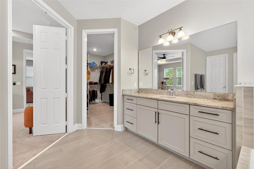 2139 Bay Line Road Oakland, FL 34787 - Photo 29 of 57 a spacious bathroom with a granite countertop sink and a mirror