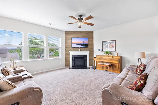a living room with furniture a fireplace and a large window