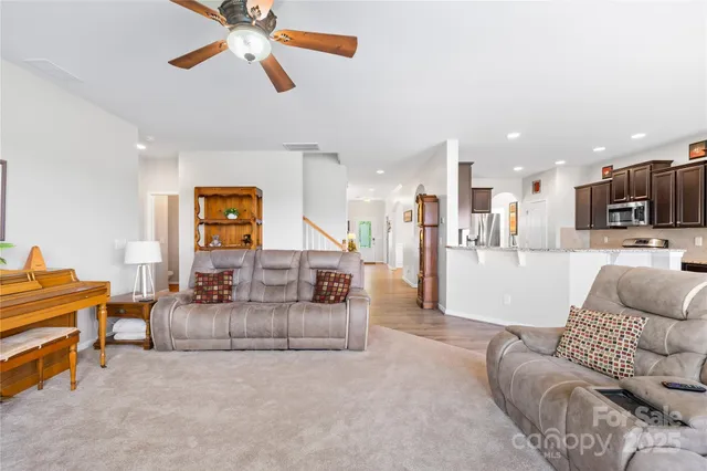 a living room with furniture and kitchen view