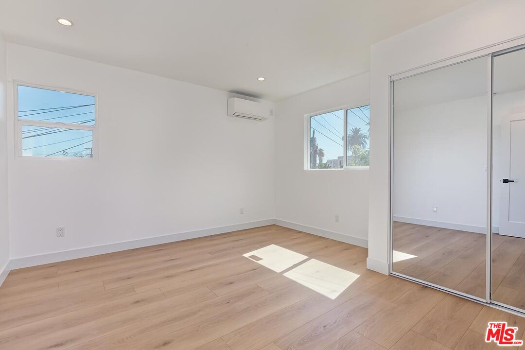 3431 Edgehill Drive Los Angeles, CA 90018 - Photo 15 of 17 an empty room with wooden floor and windows