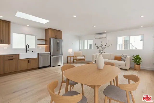 a kitchen with stainless steel appliances granite countertop a kitchen island a stove a table and chairs