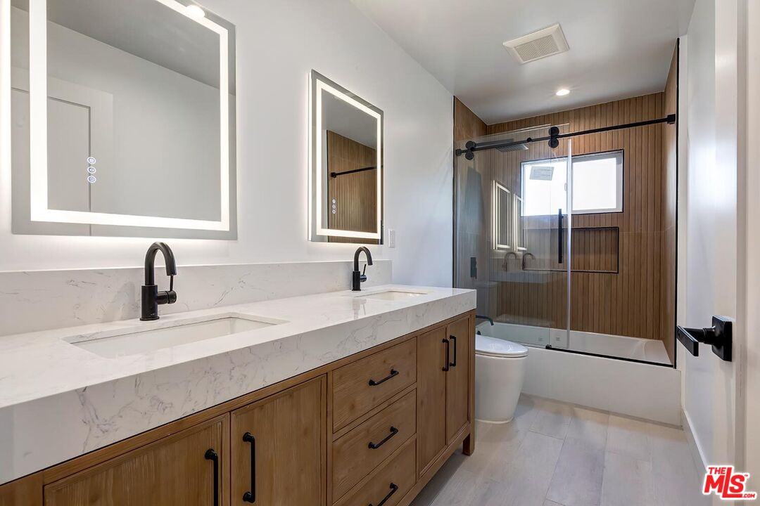 3431 Edgehill Drive Los Angeles, CA 90018 - Photo 6 of 17 a bathroom with a double vanity sink toilet mirror and bathtub