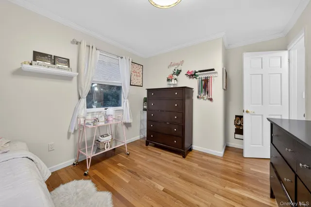 a room with a bed and a flat tv screen on the dresser