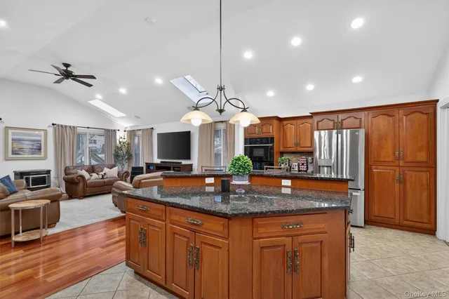 a kitchen with stainless steel appliances granite countertop a sink a stove and a refrigerator