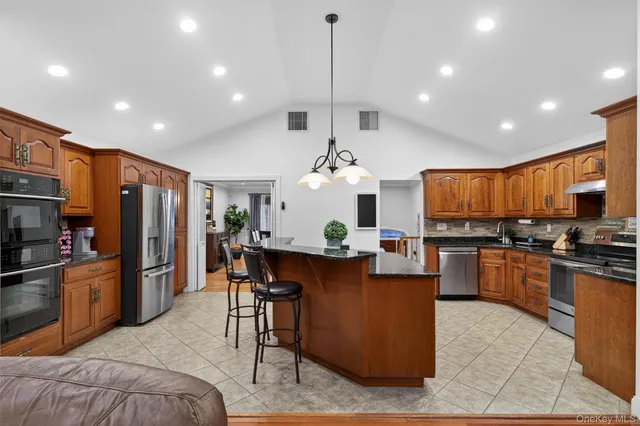 a kitchen with stainless steel appliances granite countertop sink stove top oven and refrigerator