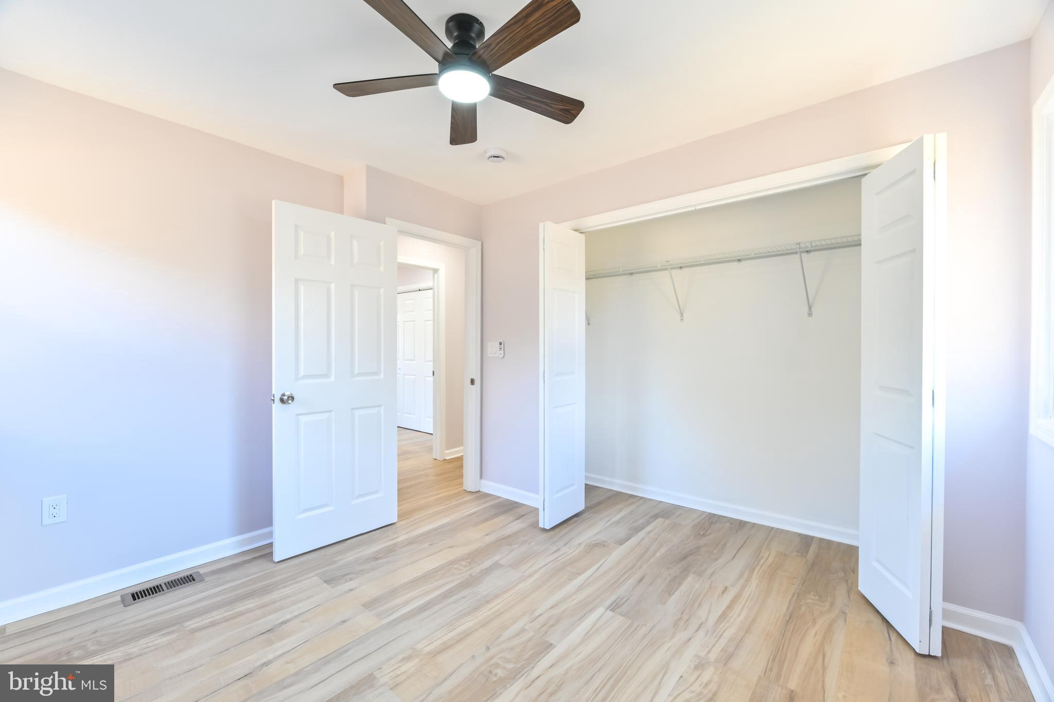 6716 Johnnycake Road Catonsville, MD 21228 - Photo 22 of 23 an empty room with wooden floor and a ceiling fan