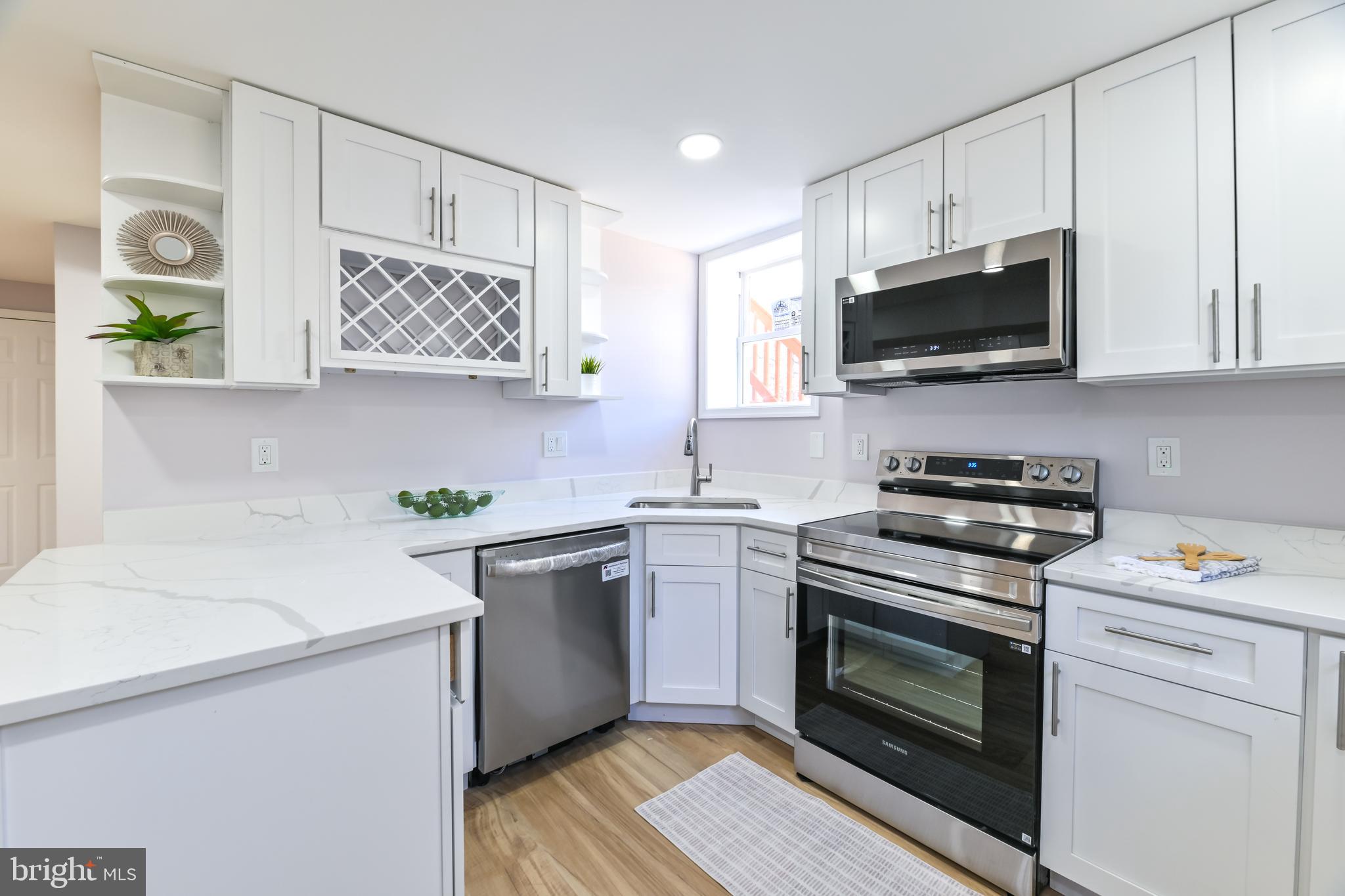 6716 Johnnycake Road Catonsville, MD 21228 - Photo 7 of 23 a kitchen with stainless steel appliances white cabinets stove a sink and a microwave