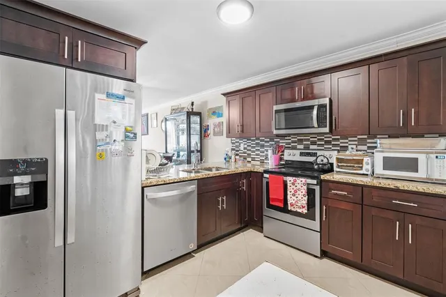 a kitchen with stainless steel appliances granite countertop a refrigerator stove and sink
