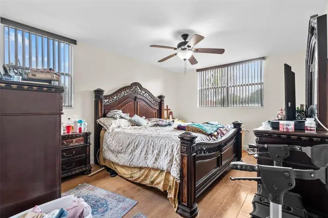 a bedroom with a bed table chair and a window